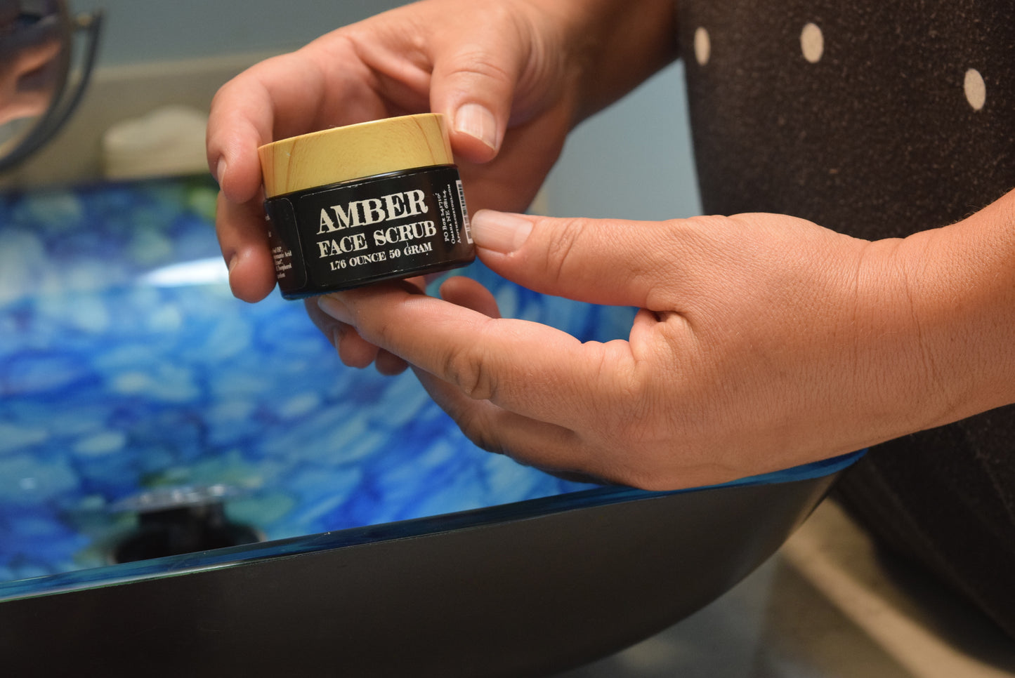 Hands holding jar of Amber Face Scrub, Apothecuryous