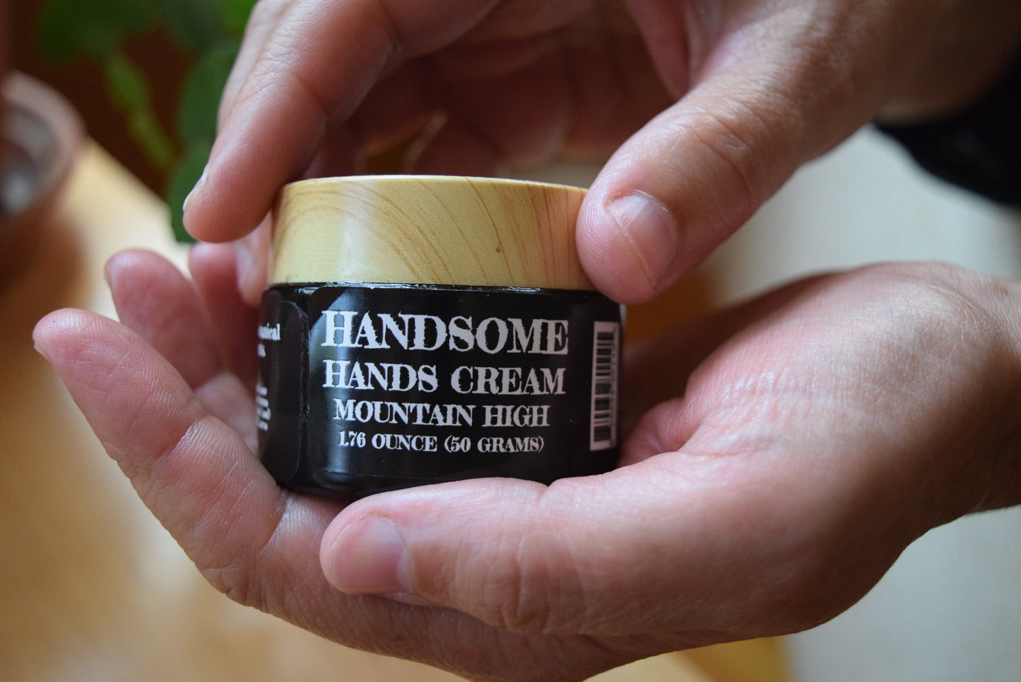 Hands holding closed jar of Handsome Hands cream, Apothecuryuous