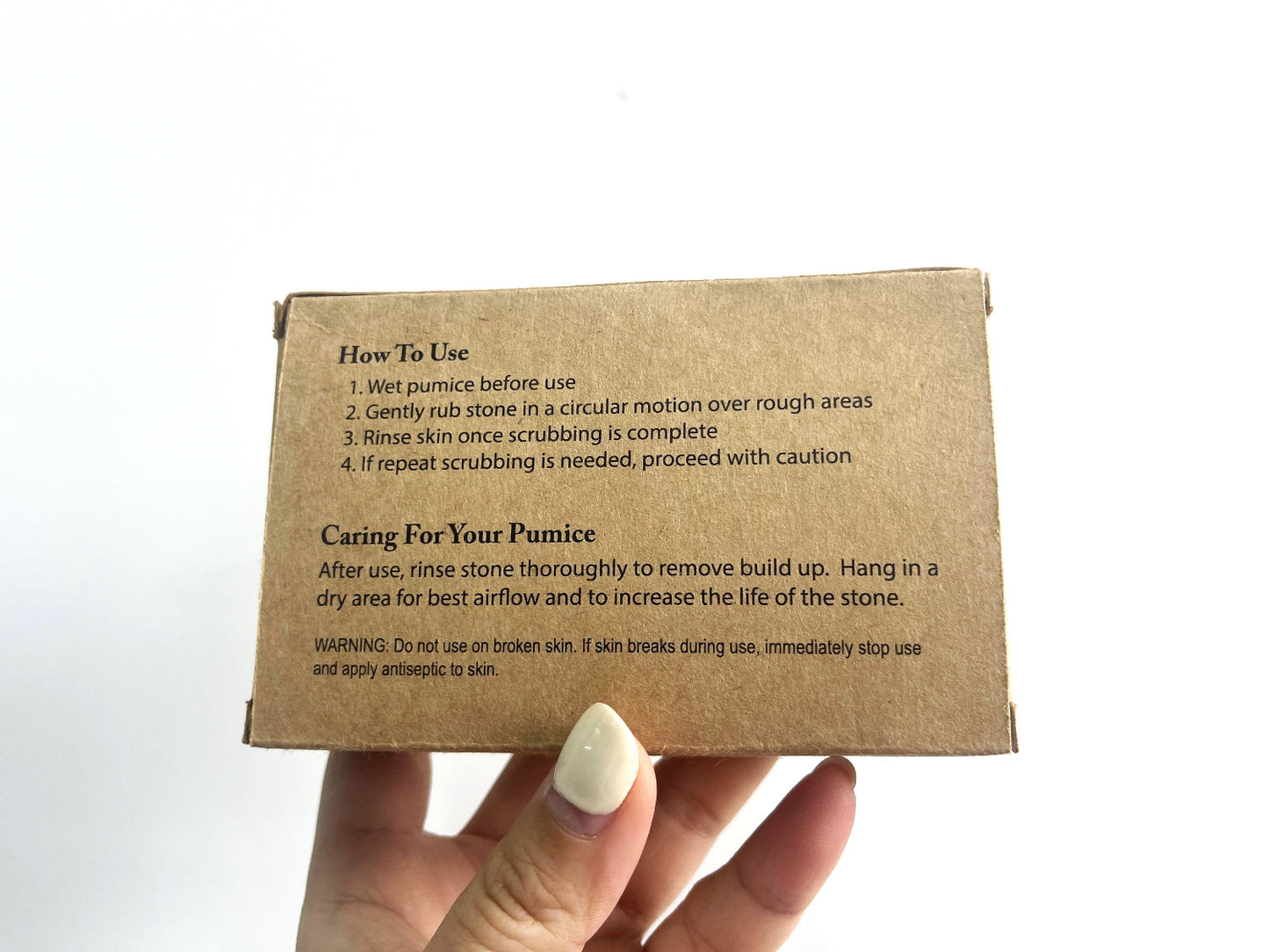 Hand holding box with Pumice stone directions and care