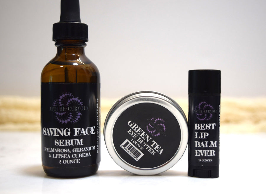 Three skincare products including a serum, eye balm, and lip balm on a light background.