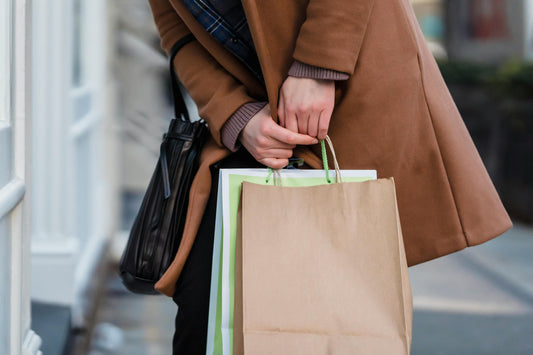 Photo by Tim Douglas : https://www.pexels.com/photo/woman-in-coat-standing-with-paper-bags-in-hands-6567651/