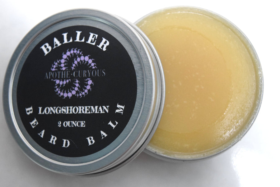 Baller beard balm in aluminum tin with lid off. Golden smooth balm showing.