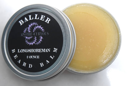 Baller beard balm in aluminum tin with lid off. Golden smooth balm showing.