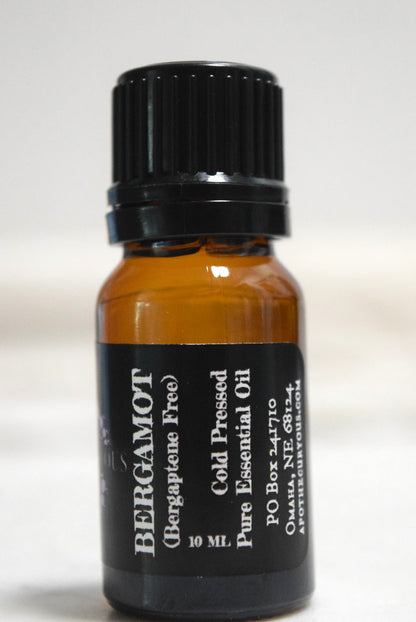 A 10 ml amber glass bottle of Bergamot essential oil with a black cap and black label, set against a plain light background, Apothecuryous