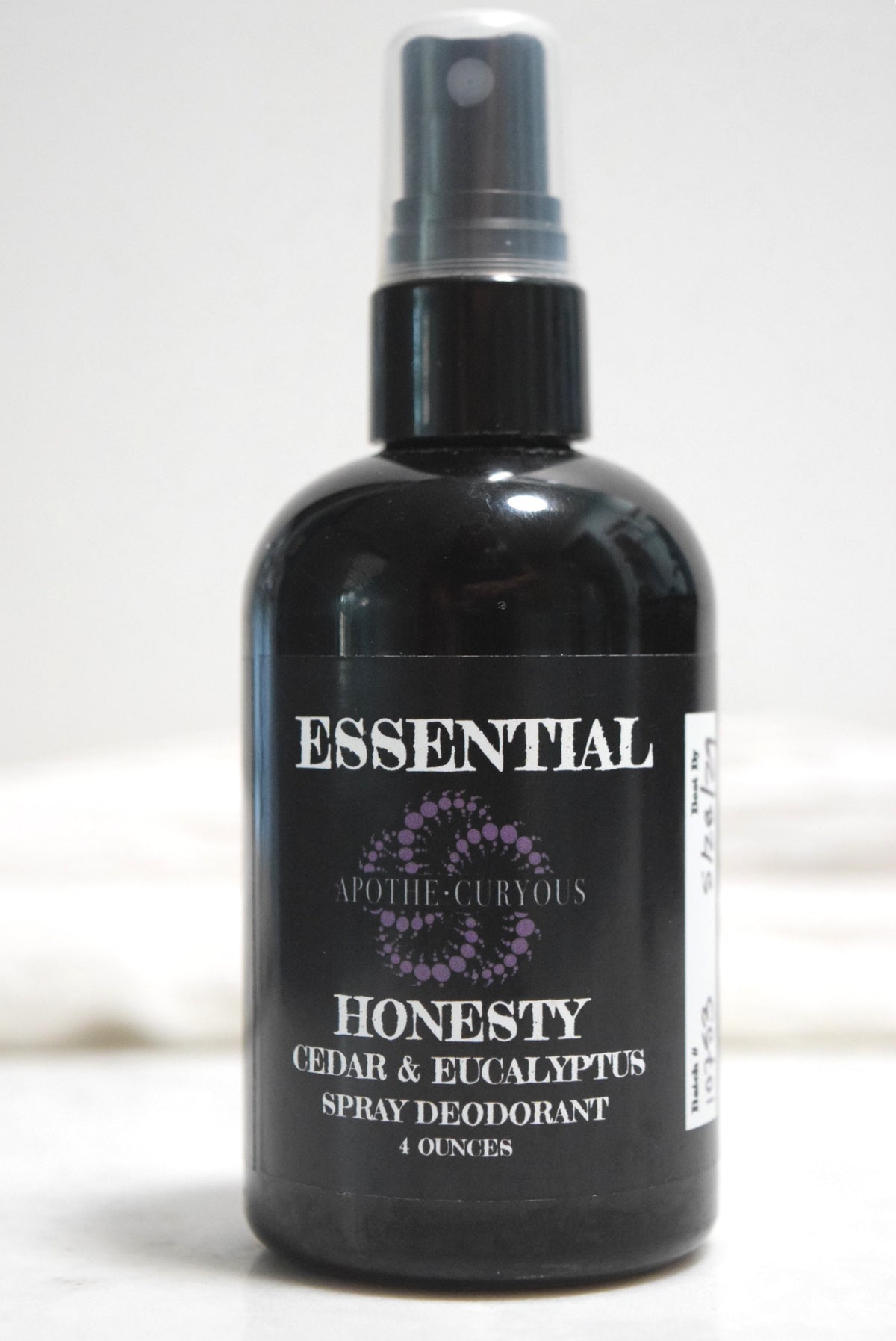 A 4-ounce black spray bottle of ApotheCuryous Honesty Cedar & Eucalyptus Natural Spray Deodorant
