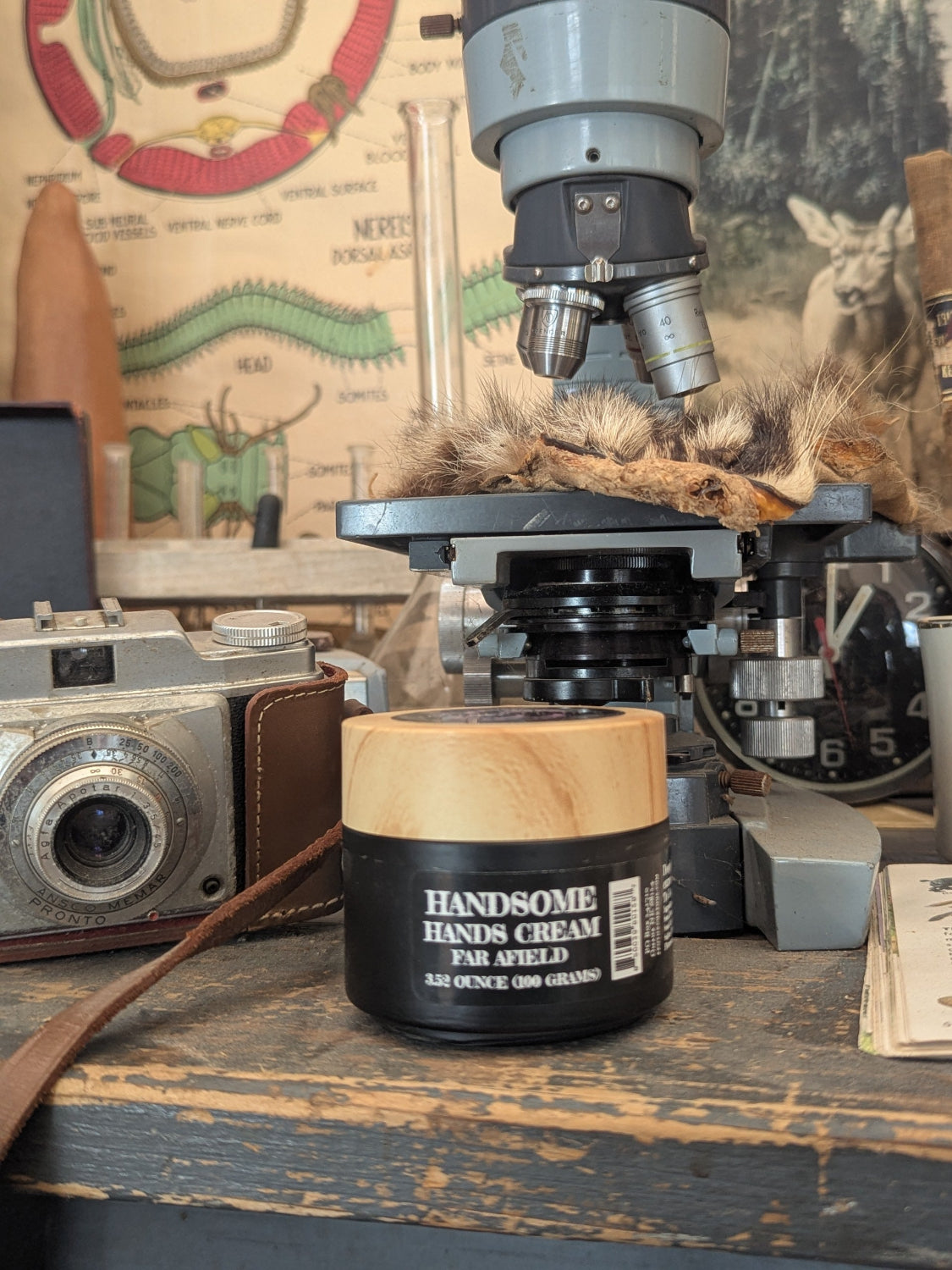 Jar of 'HANDSOME HANDS CREAM' on a table with vintage items in the background