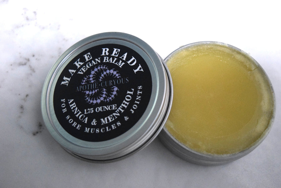 Vegan balm for sore muscles and joints in aluminum tin, lid off, Apothecuryous