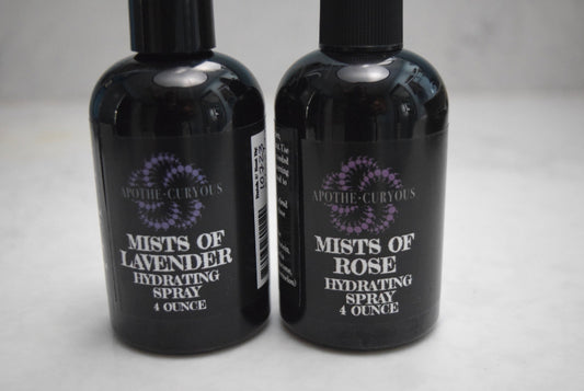 Two black spray bottles labeled 'Mists of Lavender' and 'Mists of Rose' on a light gray background.