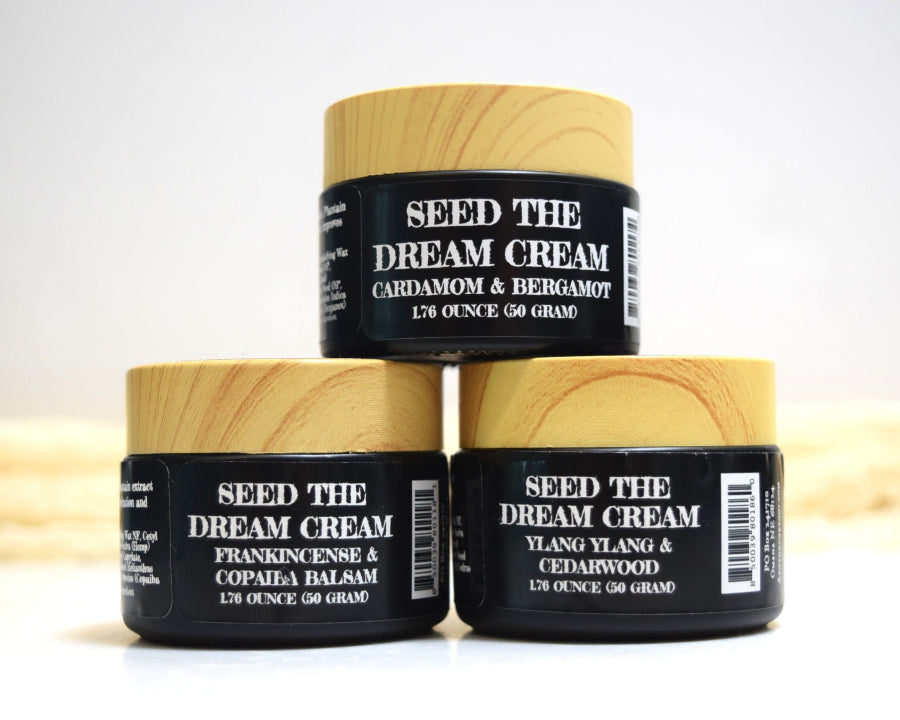 Three jars of 'Seed the Dream Cream' on a white background
