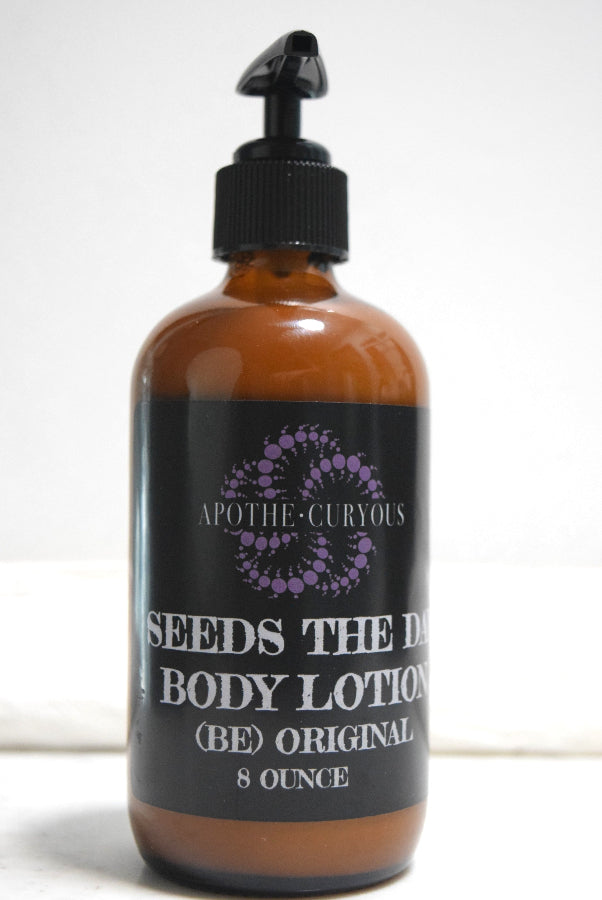 An 8-ounce amber glass bottle of body lotion with a black pump dispenser and a black label. 'SEEDS THE DAY BODY LOTION (BE) ORIGINAL'. Apothecuryous