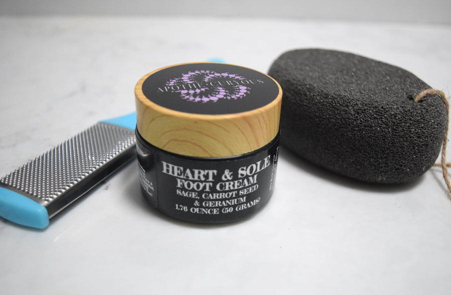 Foot cream jar with a pumice stone and a file on a white surface