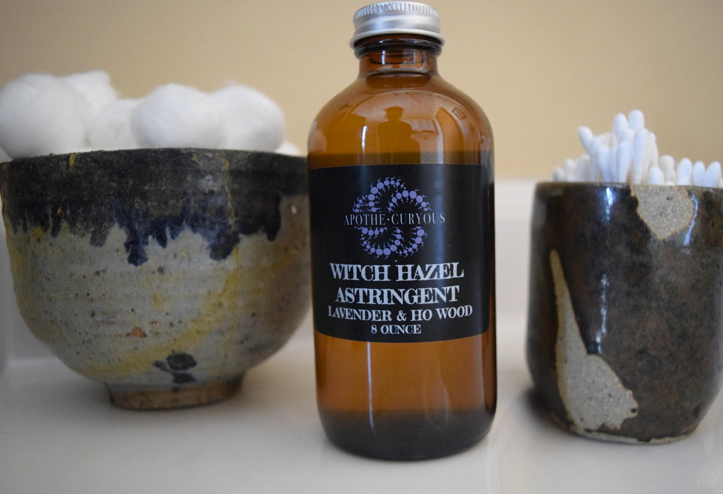 Witch Hazel in amber glass bottle with cotton balls