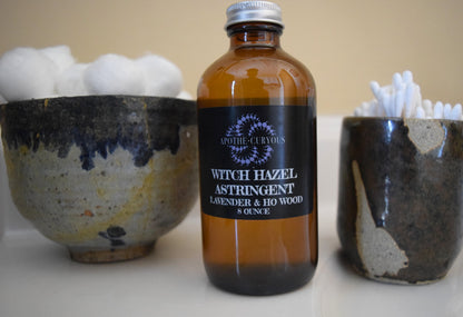 Witch Hazel in amber glass bottle with cotton balls