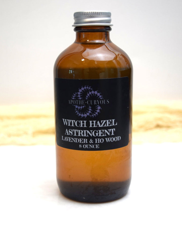 Brown glass bottle of witch hazel astringent with a black label on a white background
