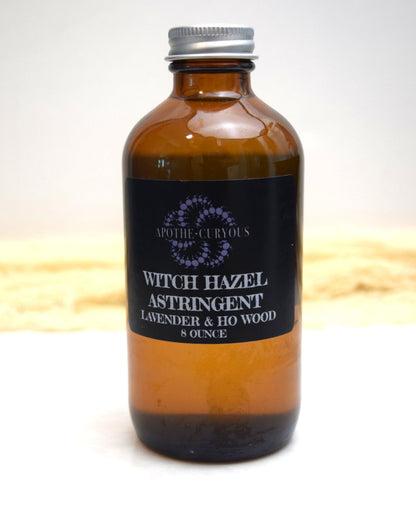 Brown glass bottle of witch hazel astringent with a black label on a white background